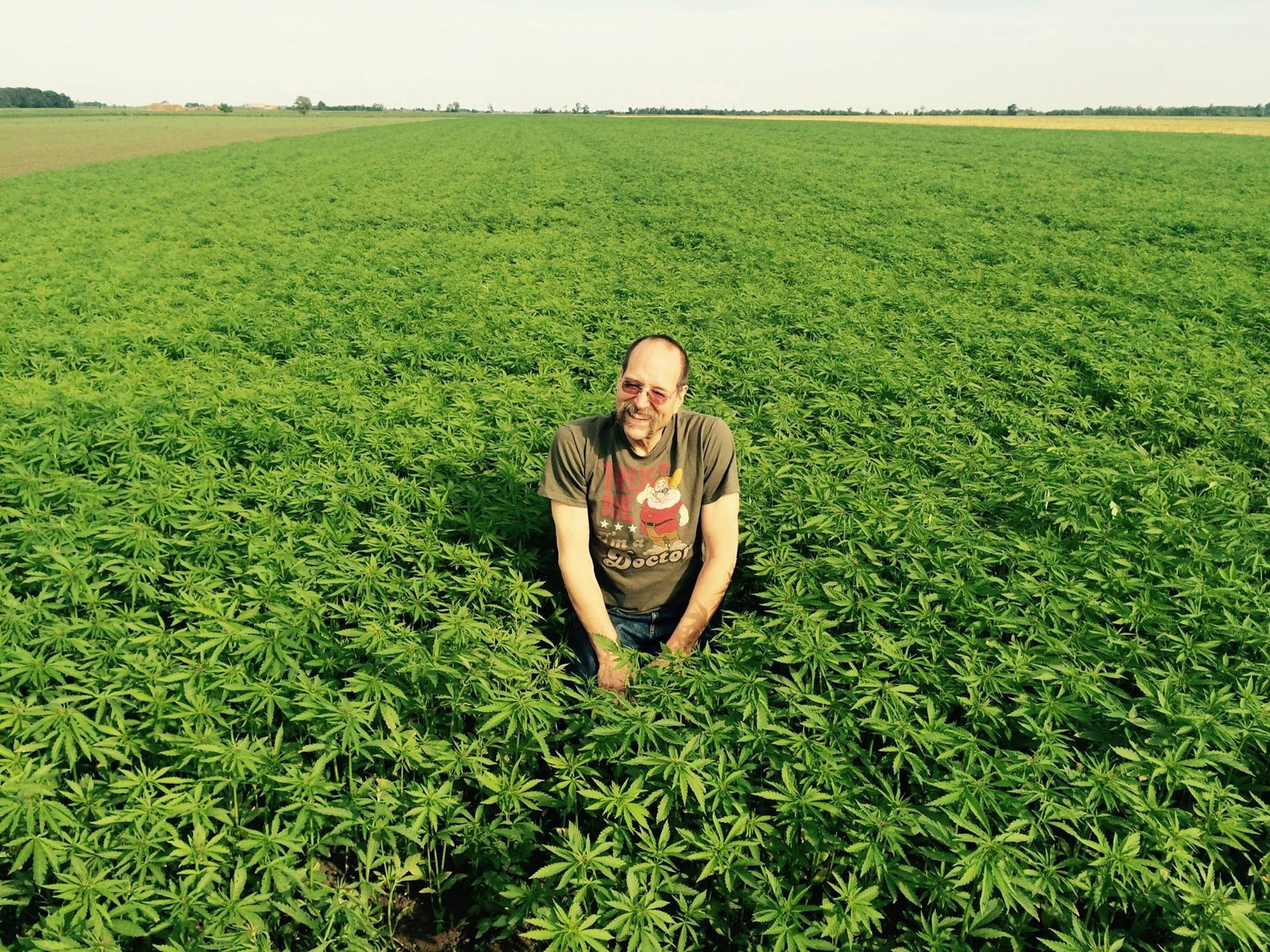 Dr. Bob Melamede standing in a hemp field, smiling